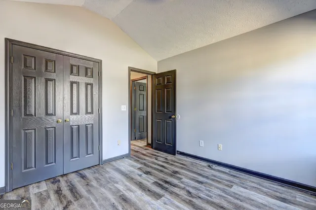an empty room with wooden floor and closet area