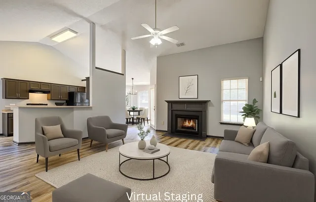 a living room with furniture a fireplace and a large mirror with wooden floor