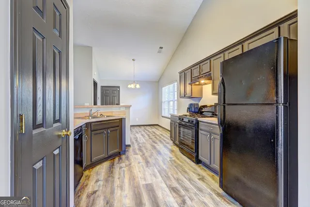 a kitchen with stainless steel appliances granite countertop a refrigerator stove and sink