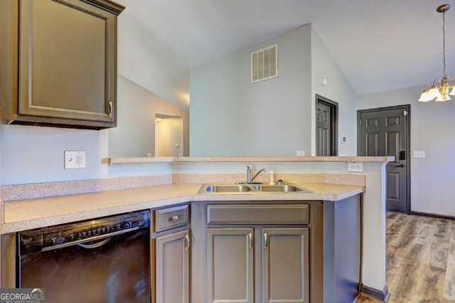 a view of a kitchen counter space a sink and dishwasher