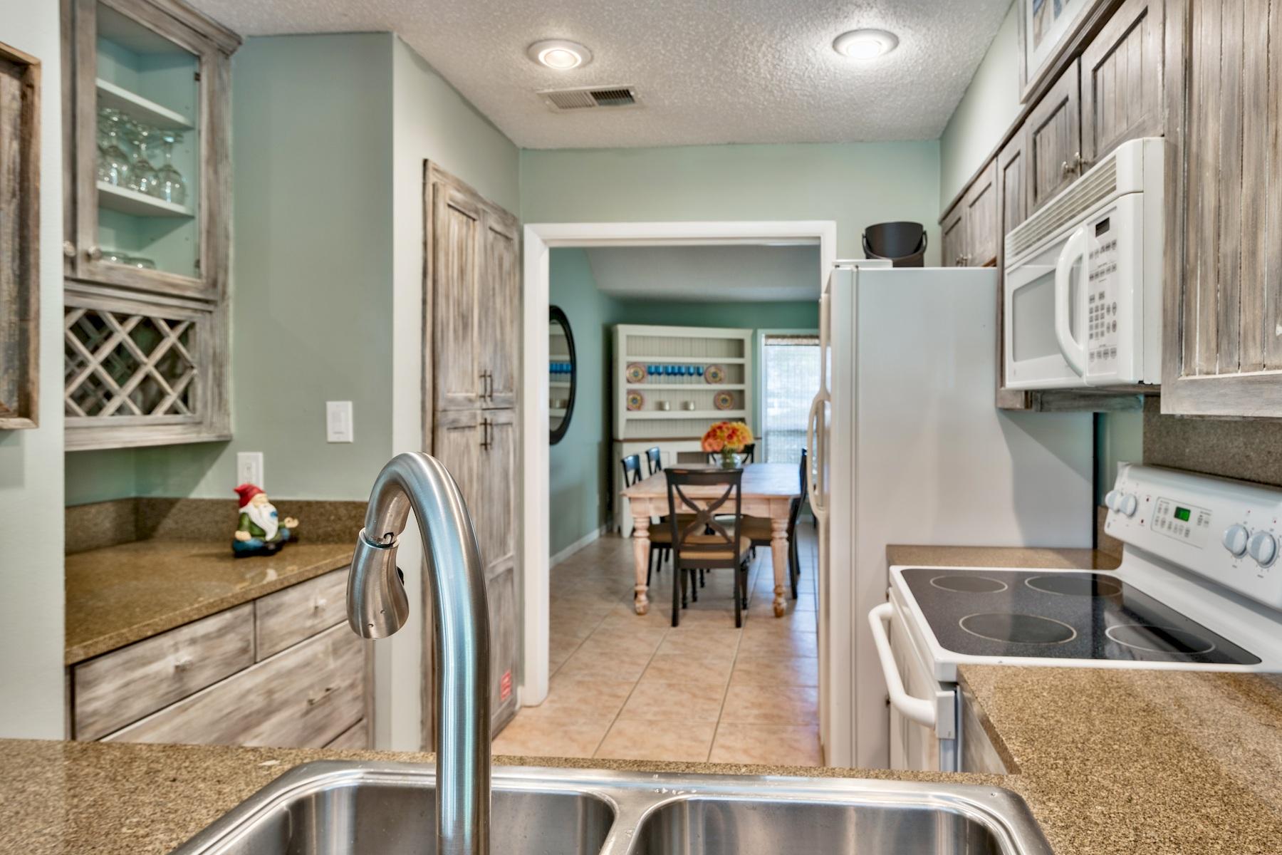 716 Sandpiper Drive, Unit 10508 Miramar Beach, FL 32550 - Photo 12 of 22 a kitchen with stainless steel appliances granite countertop a sink and a refrigerator