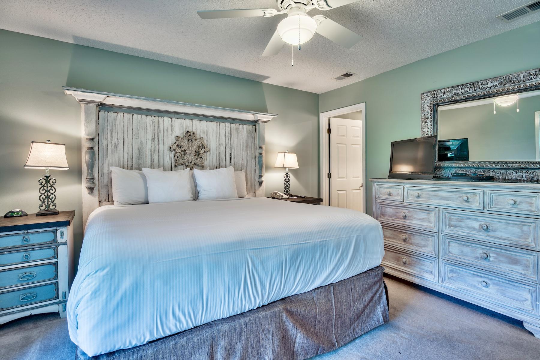 716 Sandpiper Drive, Unit 10508 Miramar Beach, FL 32550 - Photo 19 of 22 a bedroom with a large bed and a flat tv screen on dresser