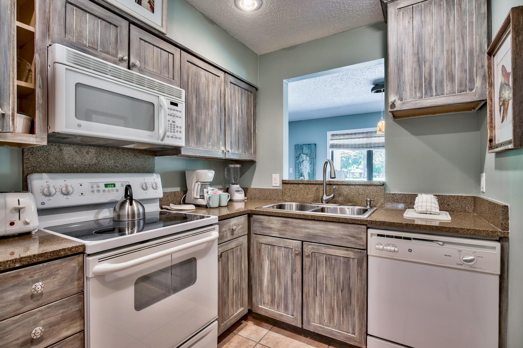 716 Sandpiper Drive, Unit 10508 Miramar Beach, FL 32550 - Photo 6 of 22 a kitchen with stainless steel appliances granite countertop a sink stove and cabinets