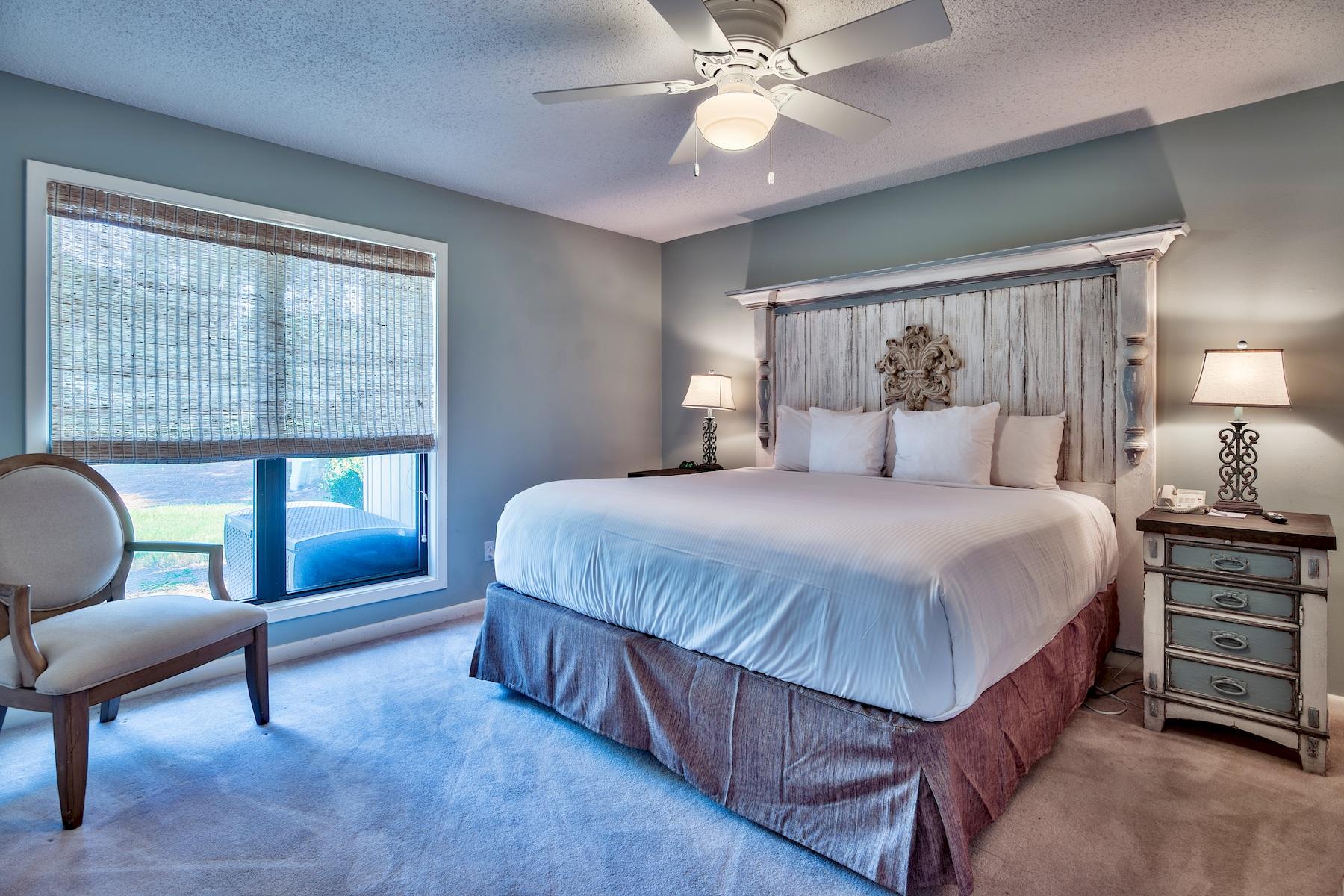 716 Sandpiper Drive, Unit 10508 Miramar Beach, FL 32550 - Photo 8 of 22 a bedroom with a bed a chair and a chandelier