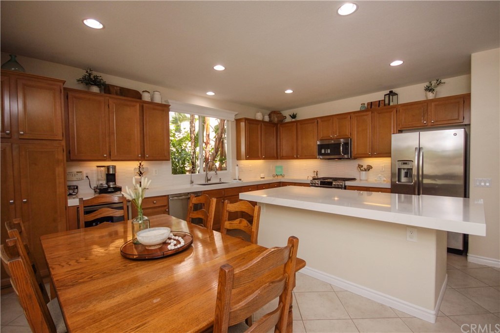 1836 Willow Bluff Drive Corona, CA 92883 - Photo 12 of 64 a kitchen with stainless steel appliances granite countertop a sink a stove a refrigerator cabinets and chairs