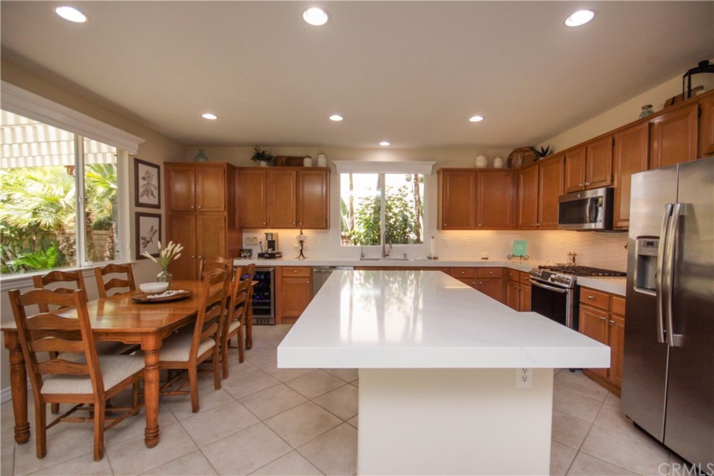 1836 Willow Bluff Drive Corona, CA 92883 - Photo 13 of 64 a large kitchen with lots of counter space dining table and stainless steel appliances