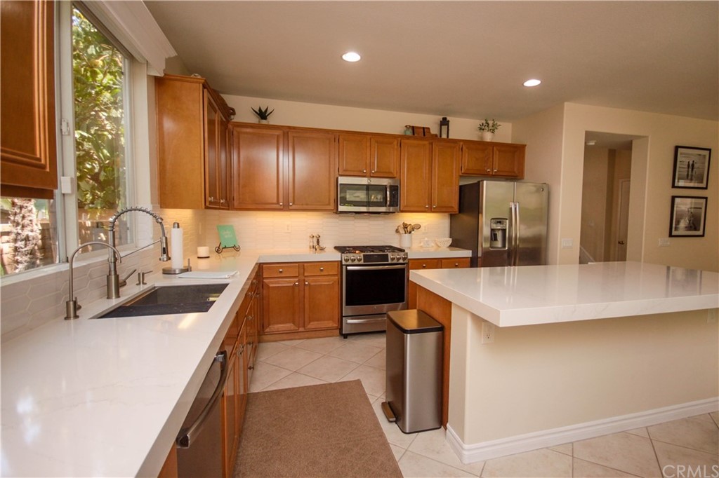 1836 Willow Bluff Drive Corona, CA 92883 - Photo 15 of 64 a kitchen with kitchen island a sink stove and refrigerator