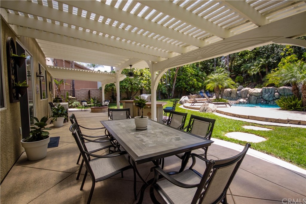 1836 Willow Bluff Drive Corona, CA 92883 - Photo 48 of 64 a view of a patio with a dining table and chairs with a wooden floor