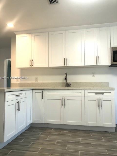 215 Southwest 10th Street Hallandale Beach, FL 33009 - Photo 1 of 14 a kitchen with granite countertop white cabinets and white appliances
