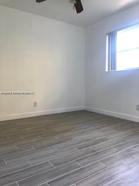 215 Southwest 10th Street Hallandale Beach, FL 33009 - Photo 11 of 14 a view of a room with wooden floor and window
