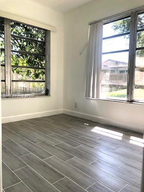 215 Southwest 10th Street Hallandale Beach, FL 33009 - Photo 12 of 14 an empty room with wooden floor and windows
