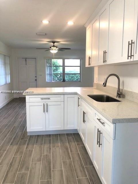 215 Southwest 10th Street Hallandale Beach, FL 33009 - Photo 2 of 14 a kitchen with a sink stove and cabinets