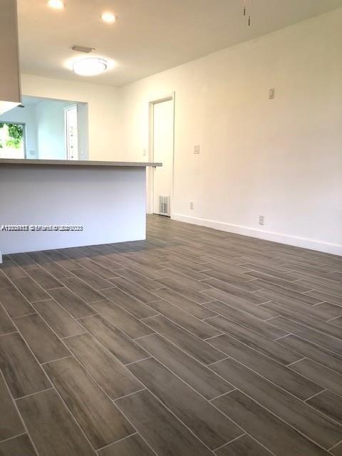 215 Southwest 10th Street Hallandale Beach, FL 33009 - Photo 5 of 14 an empty room with wooden floor and windows