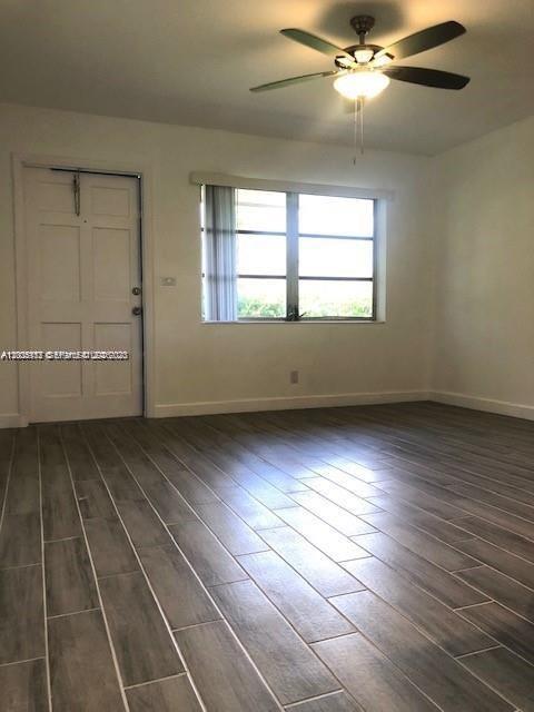 215 Southwest 10th Street Hallandale Beach, FL 33009 - Photo 7 of 14 an empty room with wooden floor and windows