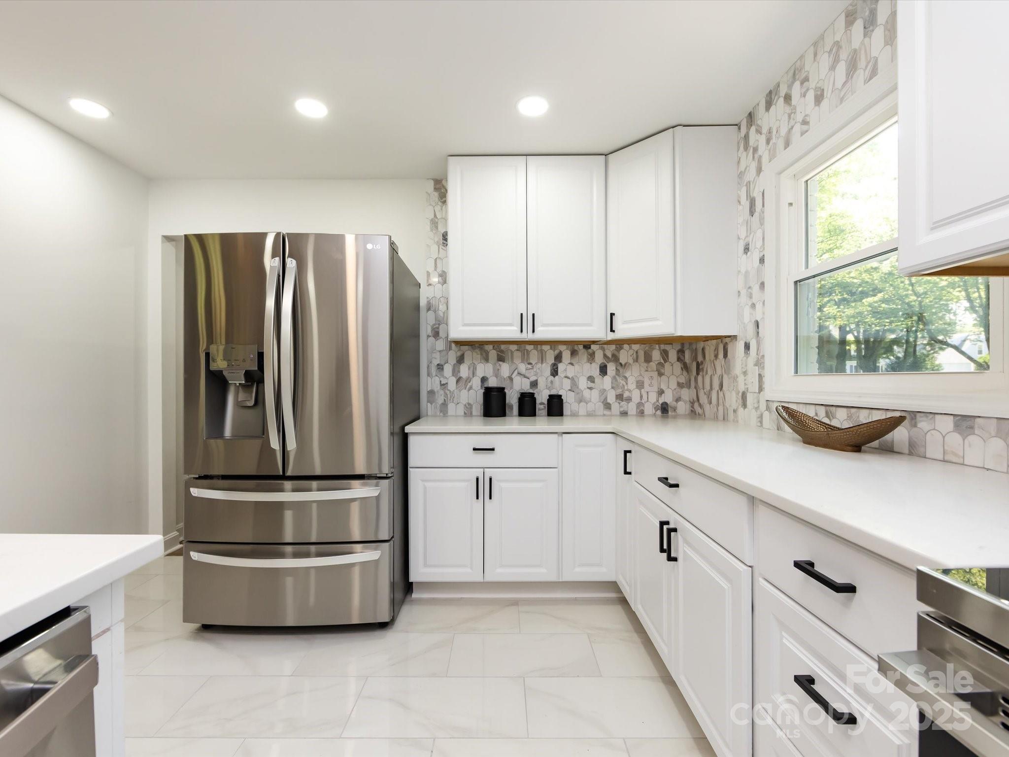 6017 Brace Road Charlotte, NC 28211 - Photo 21 of 47 a kitchen with kitchen island a refrigerator sink and cabinets