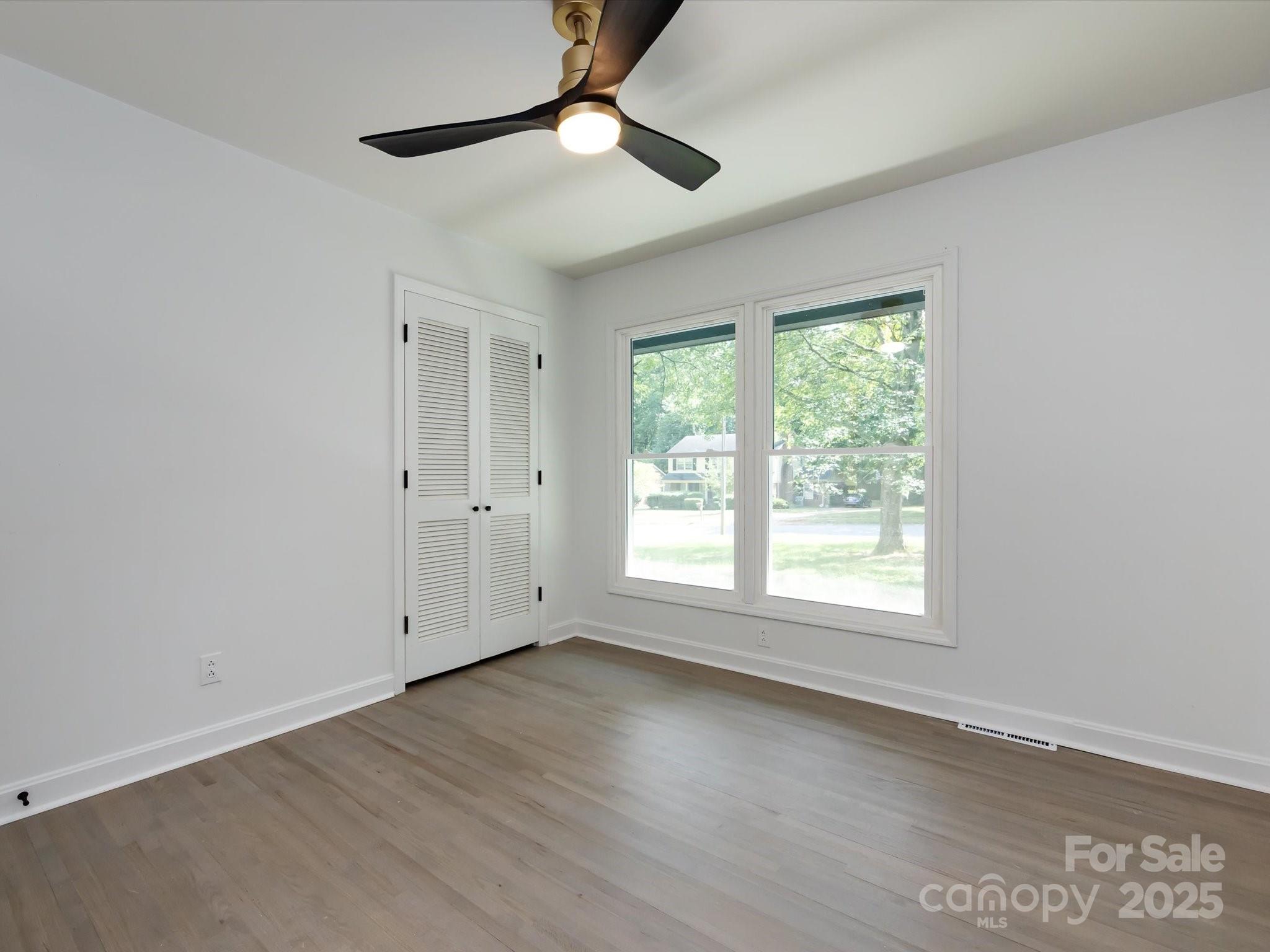 6017 Brace Road Charlotte, NC 28211 - Photo 32 of 47 an empty room with wooden floor fan and windows