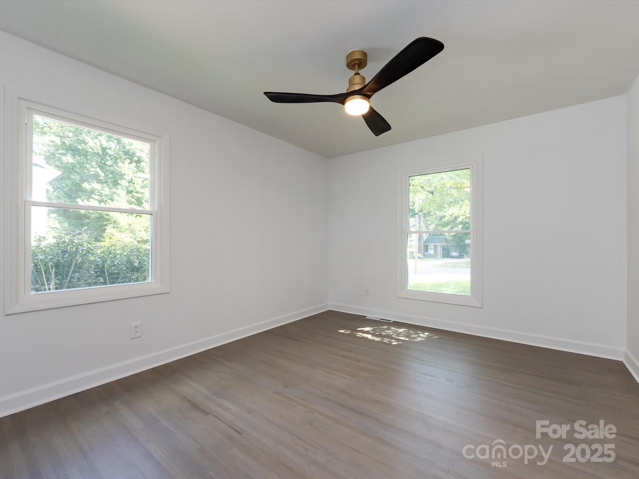 6017 Brace Road Charlotte, NC 28211 - Photo 37 of 47 an empty room with wooden floor fan and windows