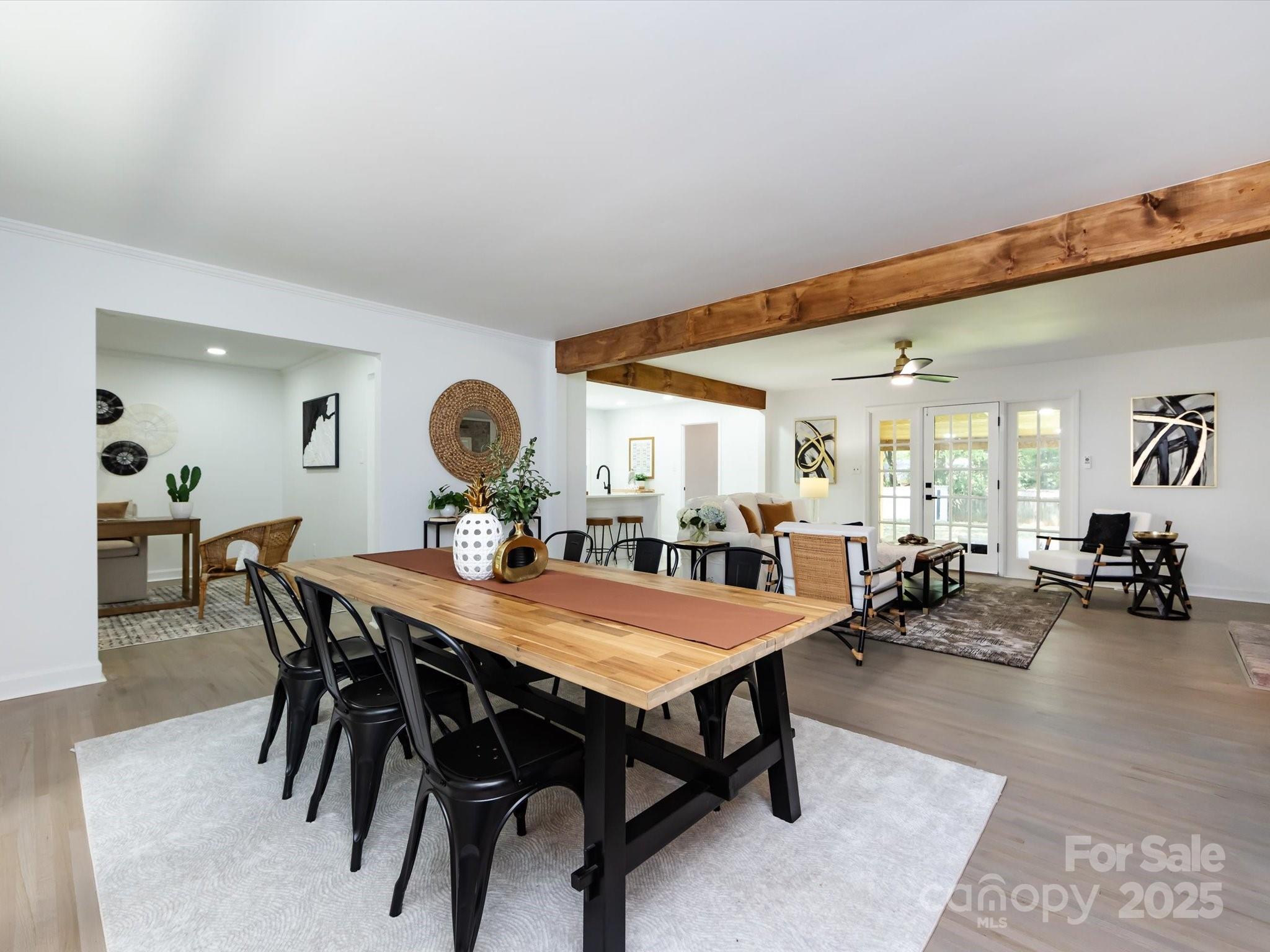 6017 Brace Road Charlotte, NC 28211 - Photo 10 of 47 a view of a dining room and livingroom with furniture wooden floor a rug and a painting