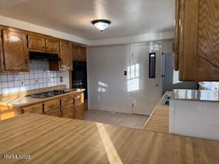 812 Lander Street, Unit A Reno, NV 89509 - Photo 5 of 24 a kitchen with stainless steel appliances wooden cabinets a sink and a stove