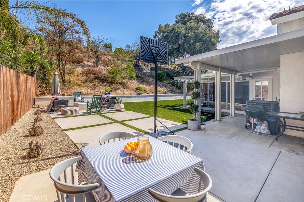 44882 Tehachapi Pass Temecula, CA 92592 - Photo 25 of 34 a view of a patio with a dining table and chairs under an umbrella