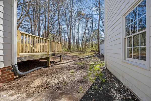 a view of a yard with chairs and wooden fence
