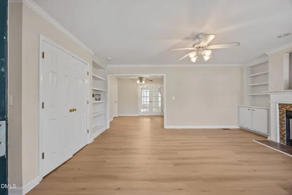 a view of an empty room with a fireplace and a window