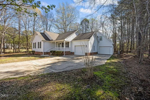 a front view of a house with a yard covered in snow