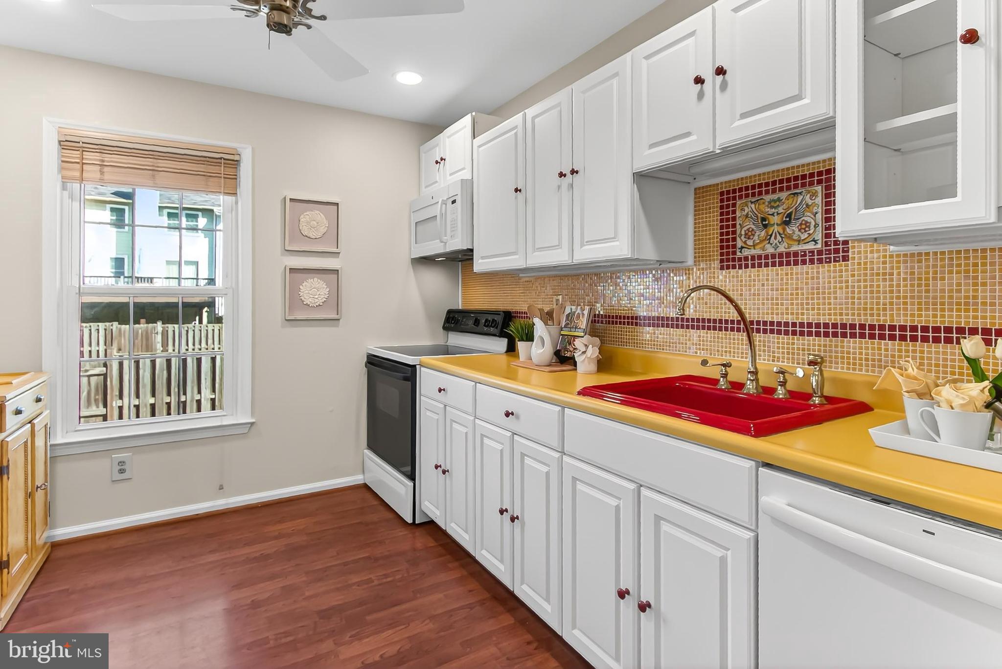 2810 Andiron Lane Vienna, VA 22180 - Photo 12 of 37 a kitchen with stainless steel appliances granite countertop a sink dishwasher and white cabinets with wooden floor