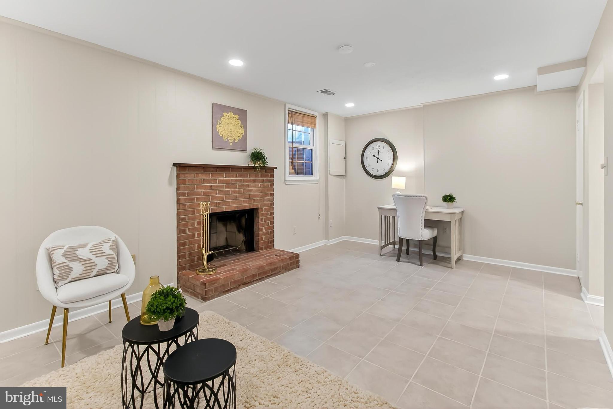 2810 Andiron Lane Vienna, VA 22180 - Photo 28 of 37 a living room with furniture a fireplace and a wall painting