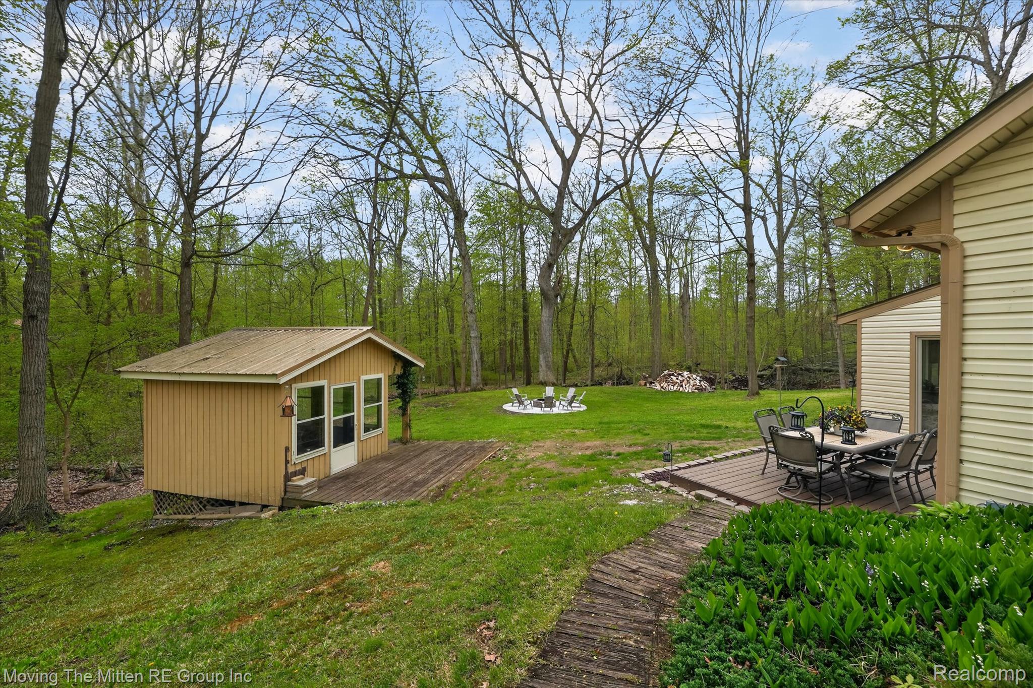 41825 Fret Road Belleville, MI 48111 - Photo 43 of 67 View of green lawn featuring a wooden deck, outdoor dining area, and an outbuilding