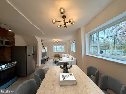 a living room with furniture a flat screen tv and a large window
