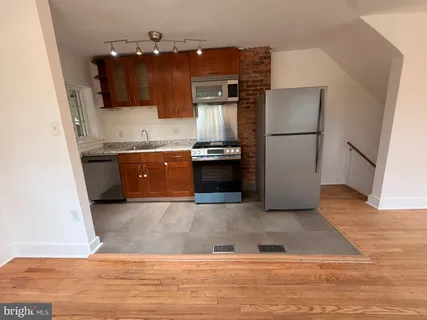 a kitchen with stainless steel appliances granite countertop a refrigerator a stove a sink and a microwave