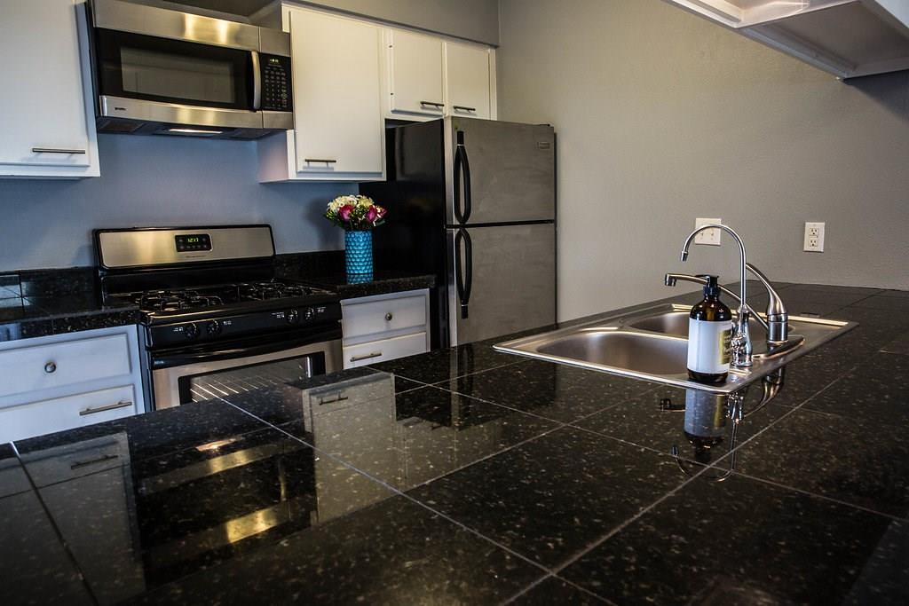 4209 Burnet Road, Unit 206 Austin, TX 78756 - Photo 5 of 20 This kitchen showcases durable granite countertops with a sleek stainless steel sink and modern appliances.
