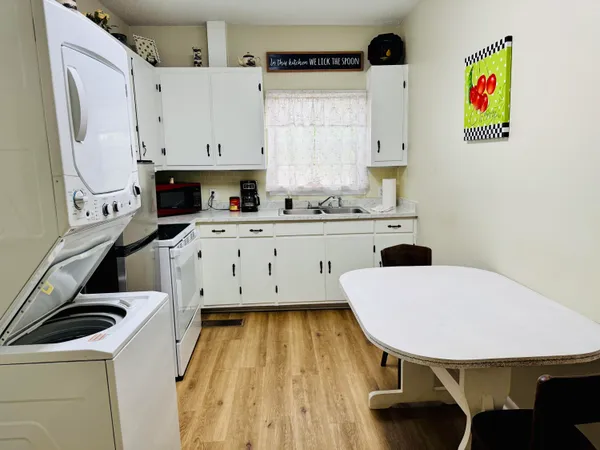 a kitchen with a table chairs sink and cabinets