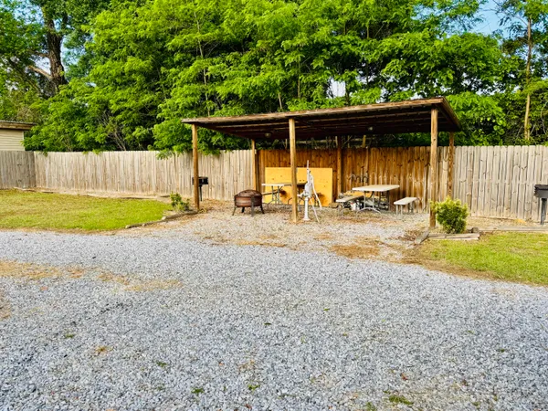a backyard of a house with barbeque oven and trees