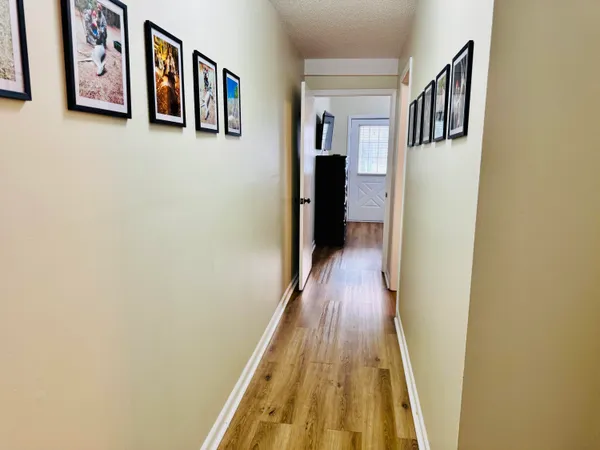a view of a hallway with wooden floor and closet