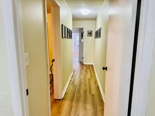 a view of a hallway with wooden floor and door
