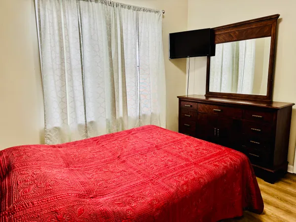 a large bed sitting in a bedroom next to a window