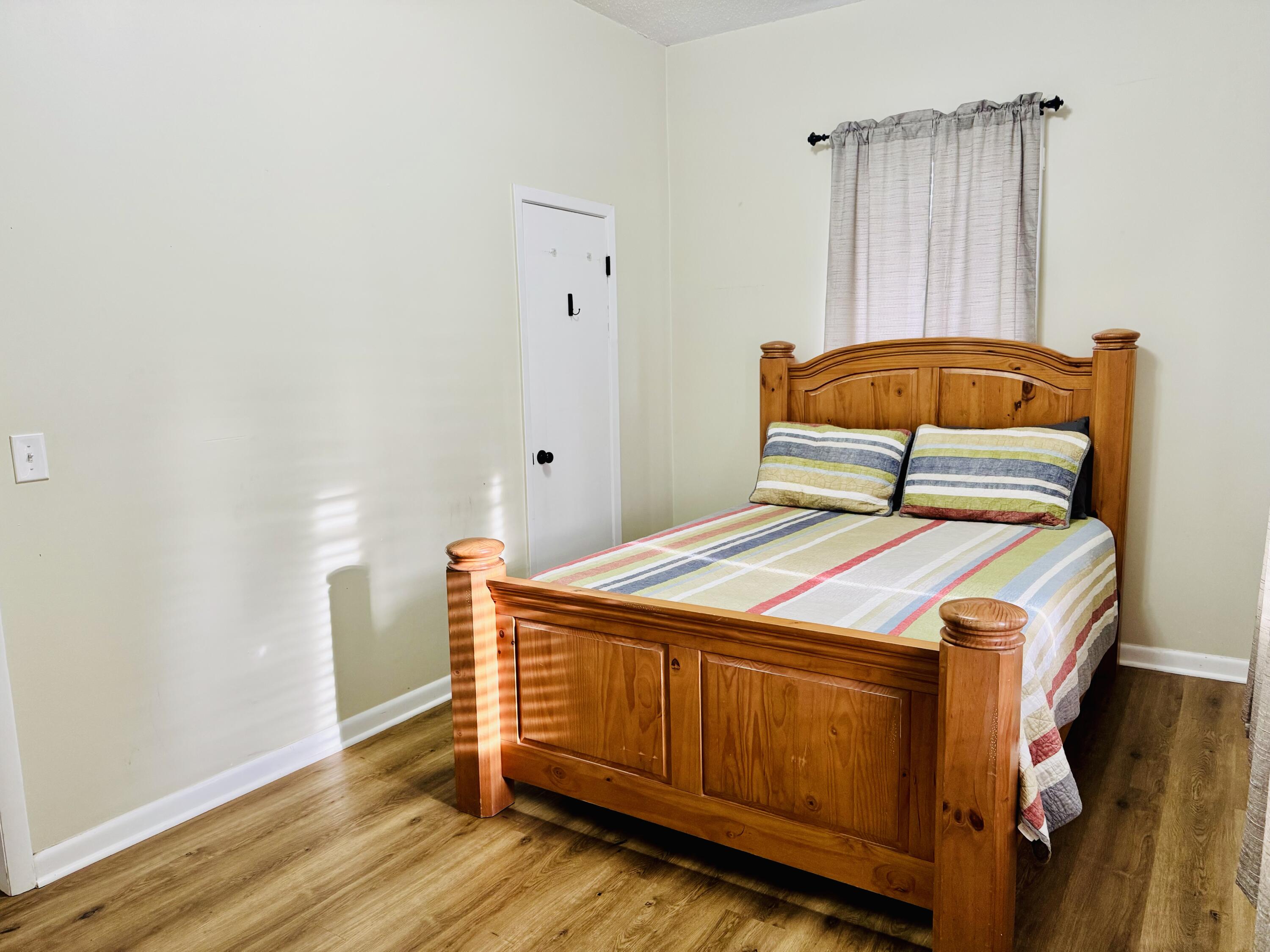 472 Claxton Avenue Elba, AL 36323 - Photo 7 of 29 a bedroom with a bed and wooden floor