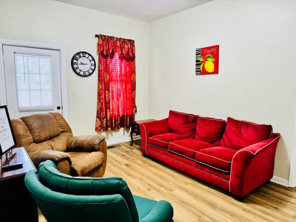a living room with furniture a rug and a wall painting
