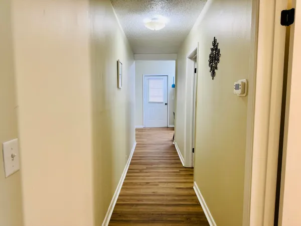 a view of a hallway with wooden floor and staircase