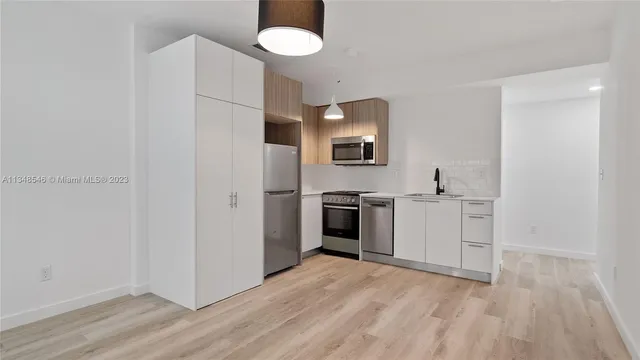 a view of a kitchen with a sink and dishwasher wooden floor