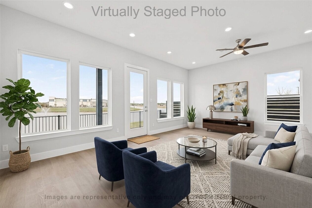 10719 Mason Road, Unit 39 Richmond, TX 77406 - Photo 11 of 50 Virtual Staging - Modern living room featuring a gray sectional sofa, two blue armchairs, and large windows with a scenic waterfront view