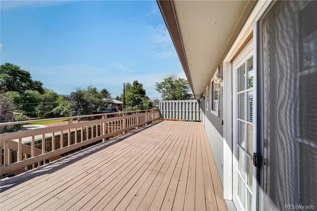 a balcony with wooden floor and fence