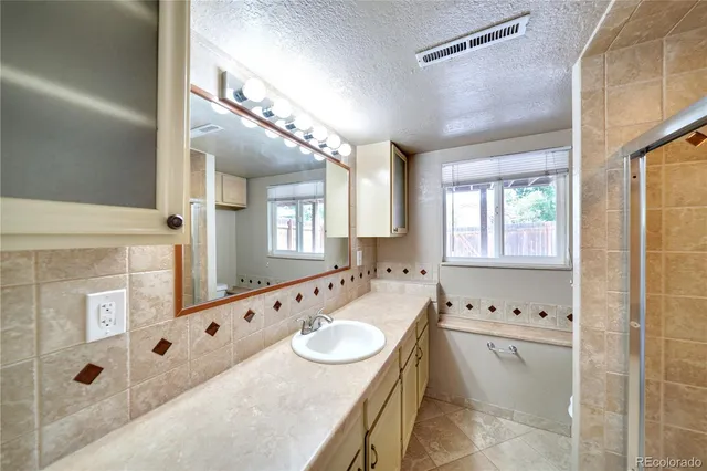 a bathroom with a tub a sink and mirror
