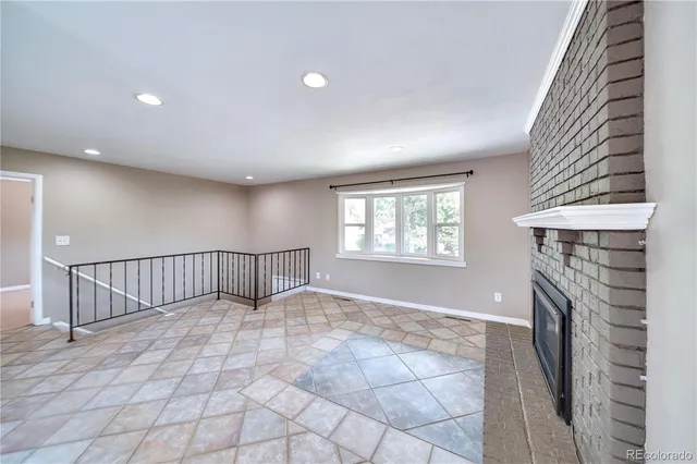 a view of an empty room with a fireplace and a window