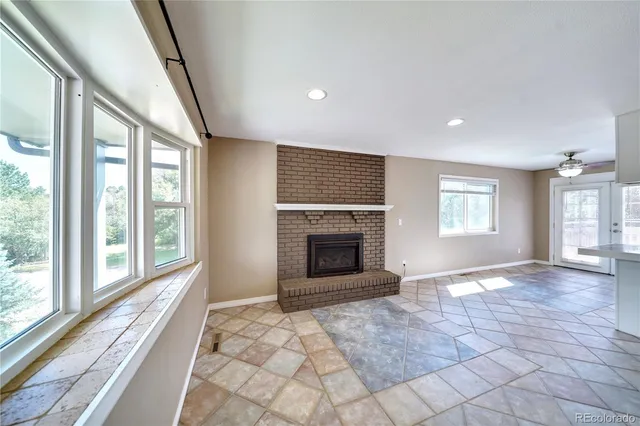 a view of an empty room with window and fire place