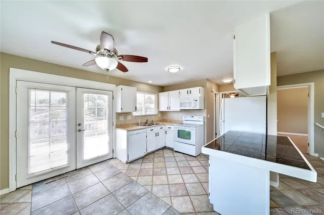 a large kitchen with a large counter top space appliances and cabinets