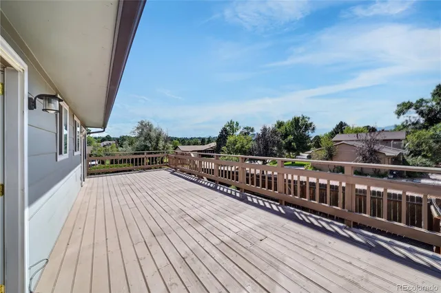 a view of balcony with wooden floor and fence