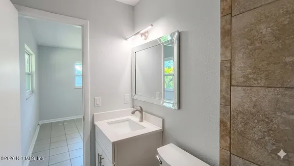 a bathroom with a toilet a sink and mirror